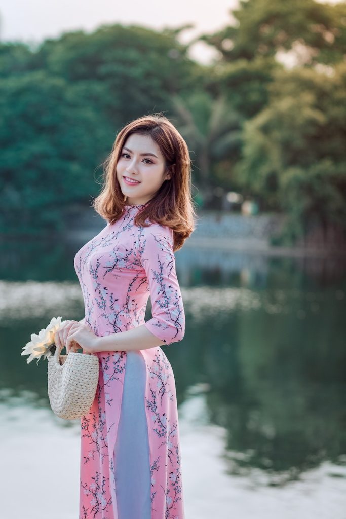 A Woman Standing and Doing Pose Beside Lake. Photo by Tuấn Kiệt Jr.