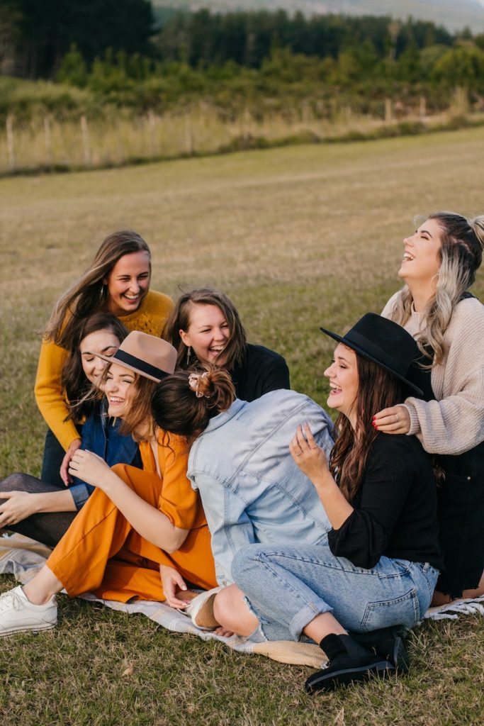 Laughing friends having fun on picnic.Photo by Ashford Marx